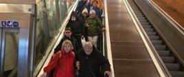 Uczestnicy na ruchomych schodach