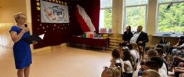 Pani dyrektor przemawia do mikrofonu do zgromadzonej młodzieży