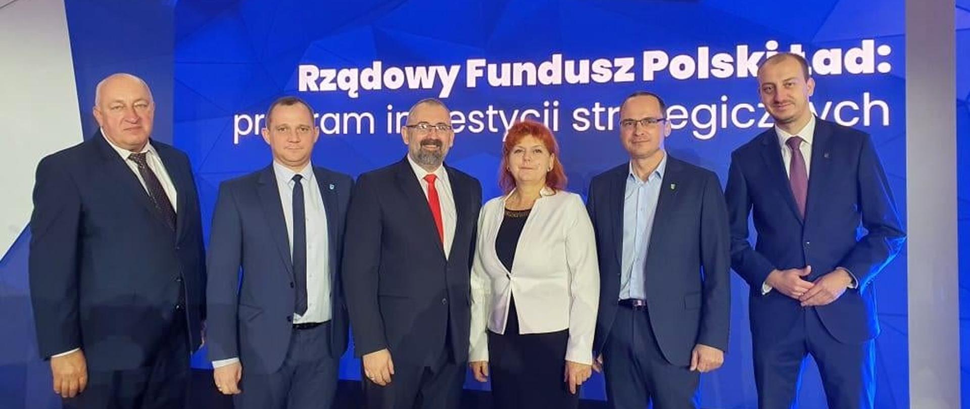 Starosta Przasnyski, Burmistrz Przasnysza i Wójtowie gmin powiatu Przasnyskiego podczas ogłoszenia wyników naboru pierwszej edycji Polskiego Ładu. Od lewej Wójt Gminy Krzynowłoga Mała Jerzy Humięcki, Wójt Gminy Krasne Michał Szczepański, Starosta Przasnyski Krzysztof Bieńkowski, Wójt Gminy Przasnysz Grażyna Wróblewska, Wójt Gminy Jednorożec Krzysztof Iwulski, Burmistrz Przasnysza Łukasz Chrostowski.