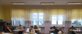  uczestnicy konkursu przy stolikach wykonują zadania