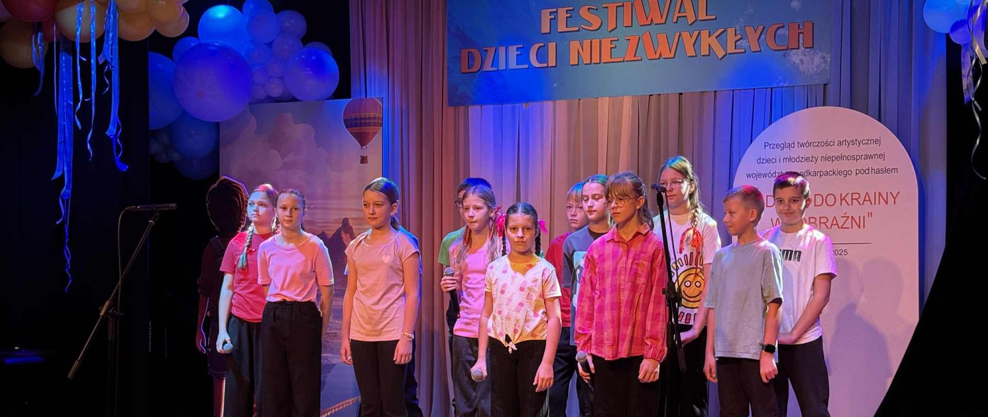 Uczniowie na scenie śpiewają piosenkę podczas otwarcia Festiwalu dzieci niezwykłych