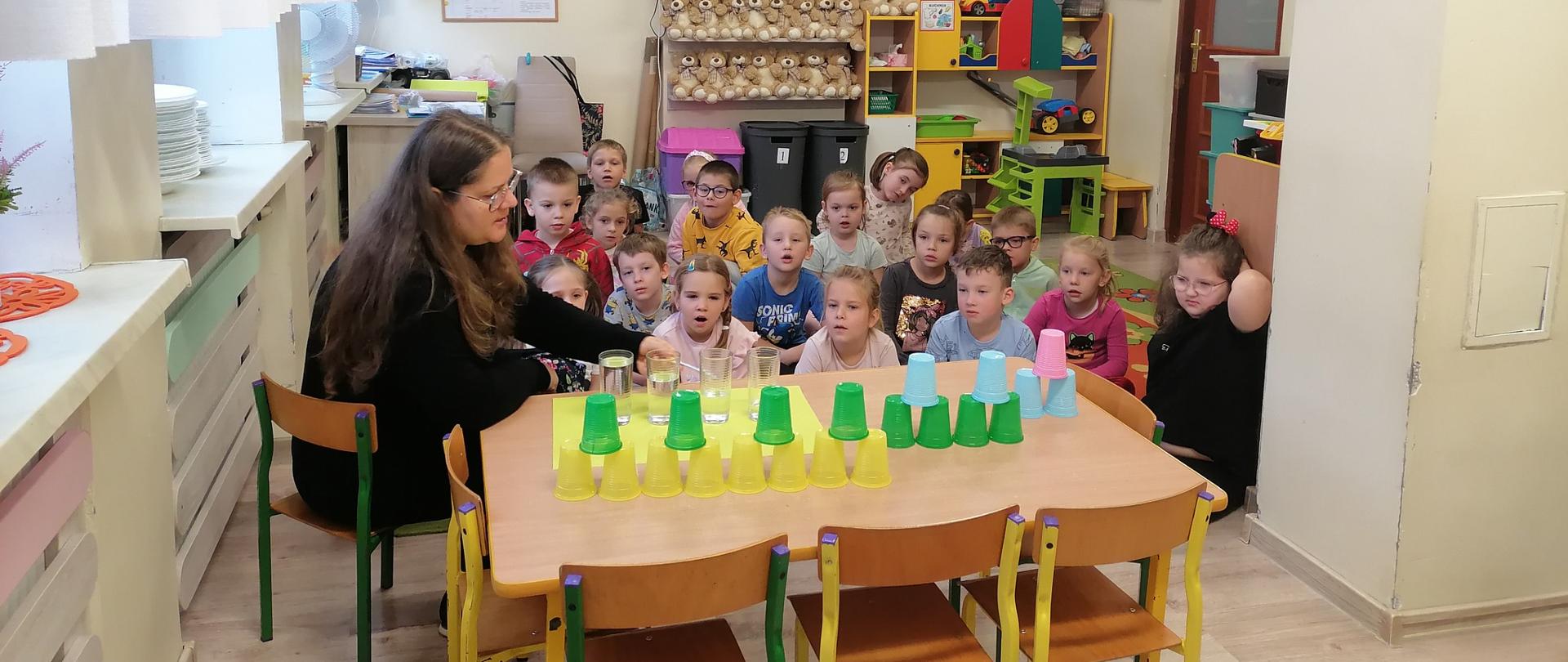 Dzieci przy stoliku z kubeczkami
