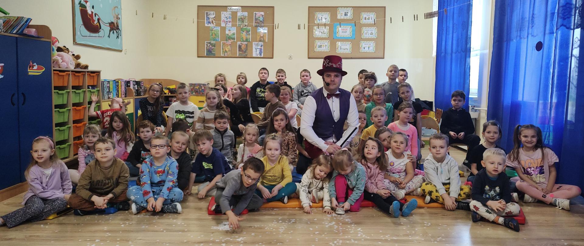 Wspólne zdjęcie przedszkolaków oraz uczniów klas I-III magikiem.