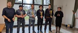 Uczestnicy wydarzenia pozują do zdjęcia z medalami i pucharami