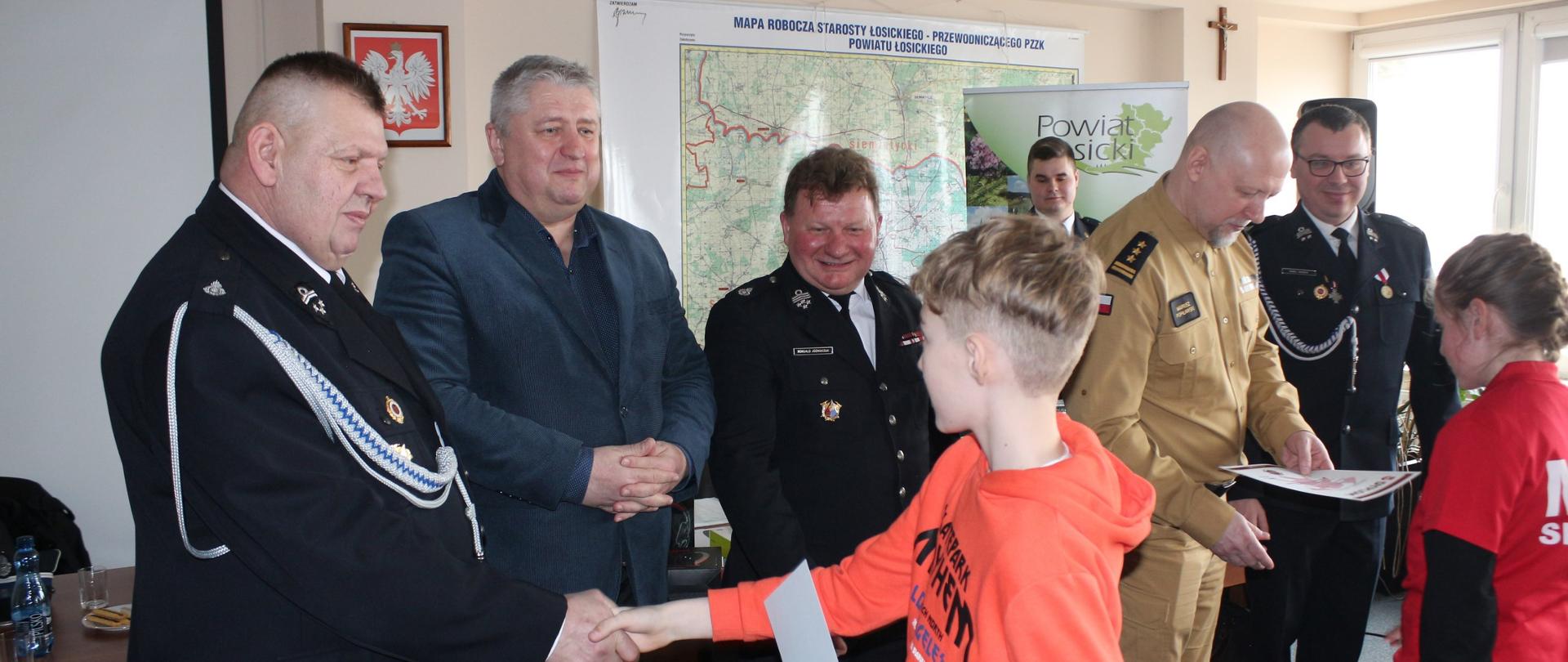 Laureaci turnieju odbierają nagrody oraz gratulacje od przedstawicieli jury turnieju, starosty łosickiego, komendanta PPSP w Łosicach oraz prezesa ZOSPRP