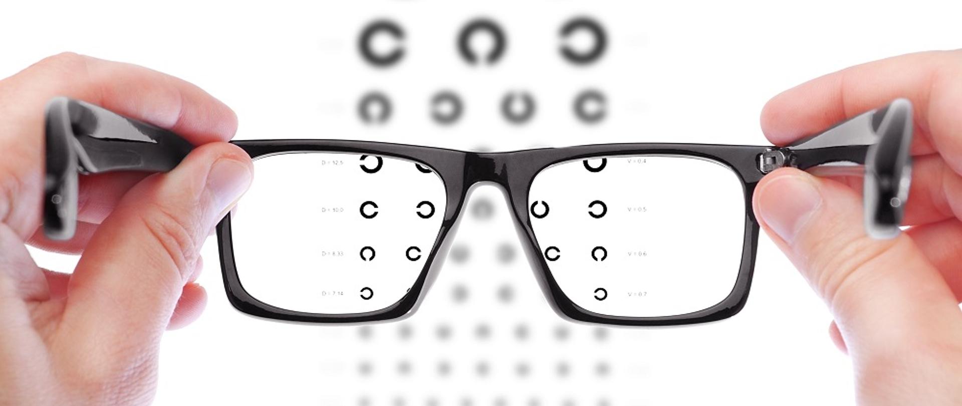 Glasses in the hands of men. Checking vision the table Golovin.
