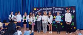 Grupa młodzieży ustawiona w rzędzie obok siebie. Ubrani w białe koszule. 