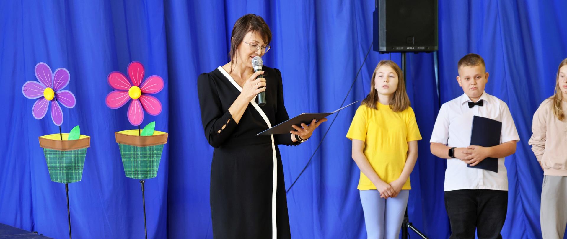 uczniowie oraz nauczyciele podczas akademii szkolnej