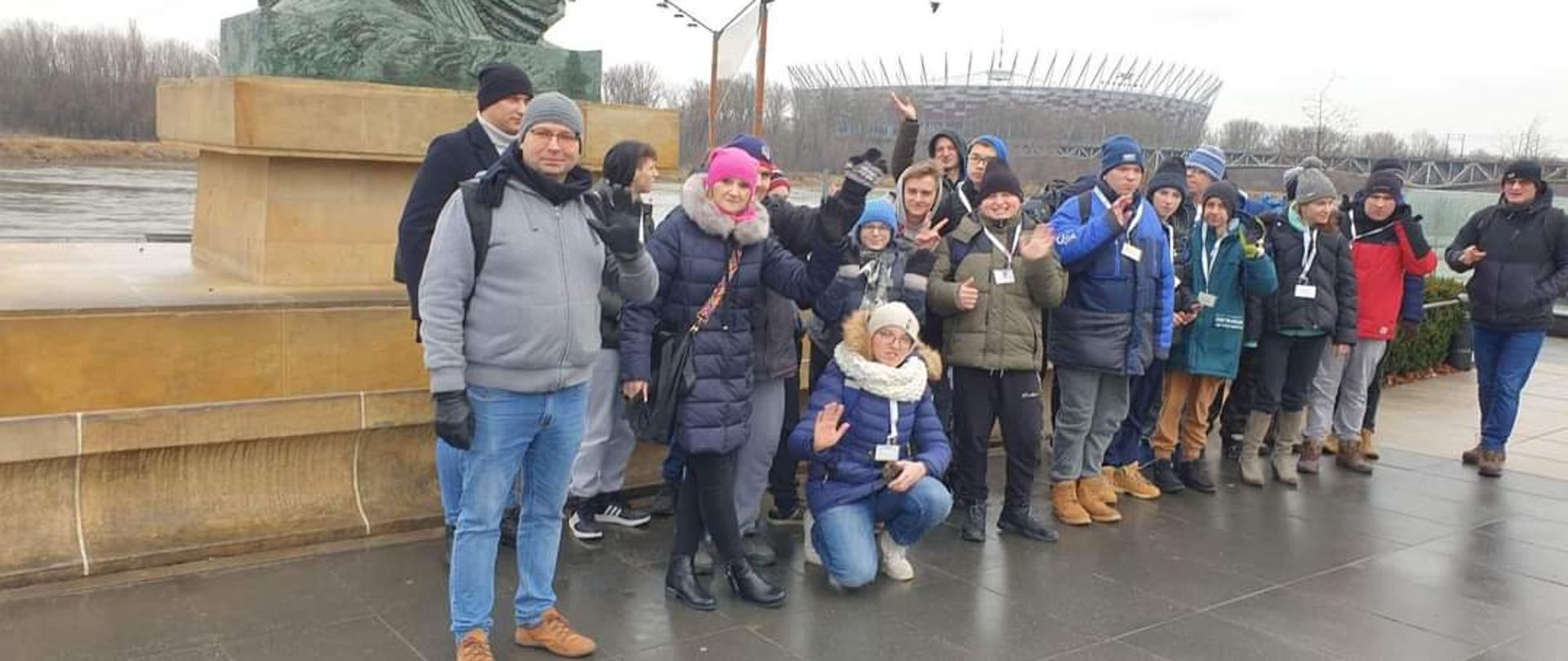 Zdjęcie uczestników wycieczki na tle stadionu