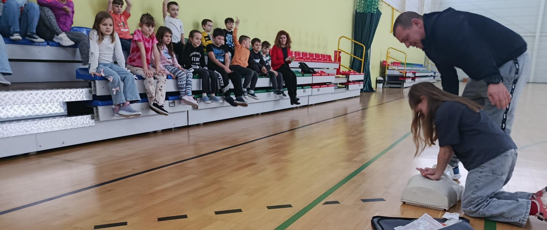 Uczennica praktycznie ćwiczy zasady udzielania pierwszej pomocy.