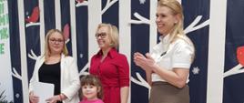 Dyrekcja Przedszkola wraz z przedstawicielką Nadleśnictwa Hajnówka wręczają nagrody dzieciom, pozując do wspólnego zdjęcia