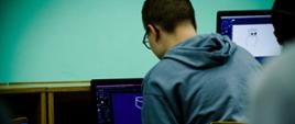 Uczeń siedzi przed komputerem, pracuje z programem graficznym