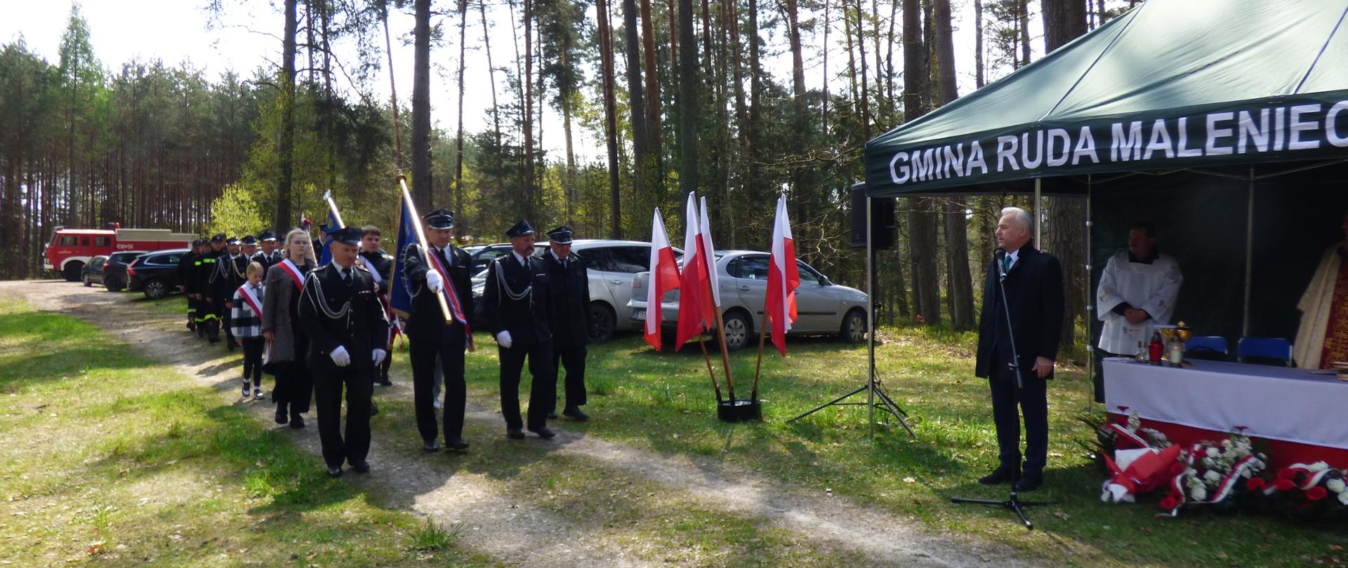 Zdjęcie przedstawia Wójta Gminy Ruda Maleniecka, wprowadzającego reprezentantów pocztów sztandarowych: OSP oraz ZPPO w Rudzie Malenieckiej, a także Szkoły Podstawowej w Dobromierzu, dalej kolejne jednostki OSP z terenu gminy Ruda Maleniecka.
