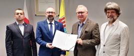 Zdjęcie przedstawia przedstawicieli Powiatu Przasnyskiego oraz Fundacji Technology Partners prezentujących wspólnie list intencyjny projektu „Centrum Zrobotyzowanych Usług dla Rolnictwa”. Od lewej: Kierownik Referatu Rozwoju, Aktywizacji Biznesu i Promocji Marek Chrzanowski, Starosta Powiatu Przasnyskiego Krzysztof Bieńkowski, prof. dr hab. inż. Krzysztof Santarek, Dyrektor ds. Projektów z Fundacji „Technology Partners” Jarosław Sołtys. 