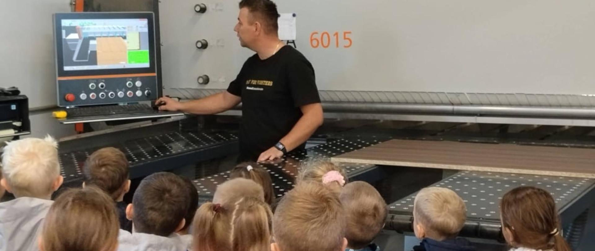 Dzieci obserwują maszyny wykorzystywane do produkcji mebli