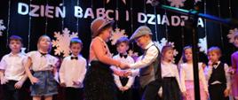 Dzieci podczas występu na scenie z okazji Dnia Babci i Dziadka