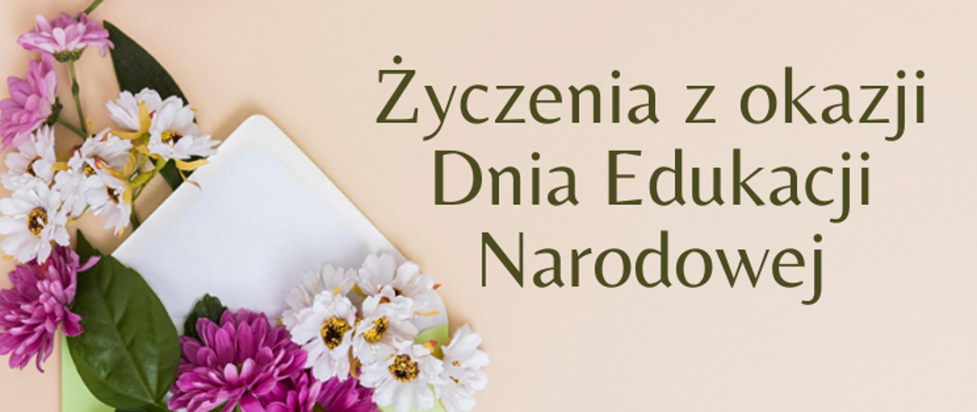 Z lewej strony znajduje się otwarta zielona koperta z białym wnętrzem. Na kopercie znajdują się różowe i białe kwiaty. Obok znajduje się ciemnozielony napis: Życzenia z okazji Dnia Edukacji Narodowej