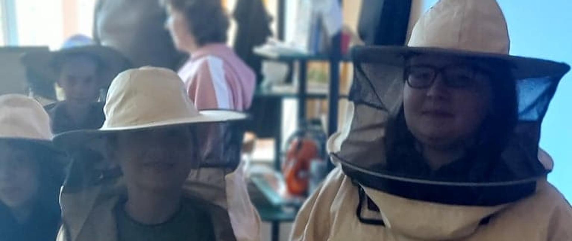 Dwoje uczniów z maskami pszczelarskimi na głowach