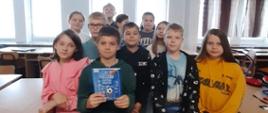 Grupa uczniów prezentuje książkę.