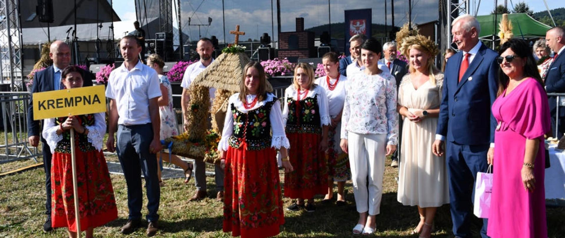 grupa osób niosących wieniec dożynkowy 