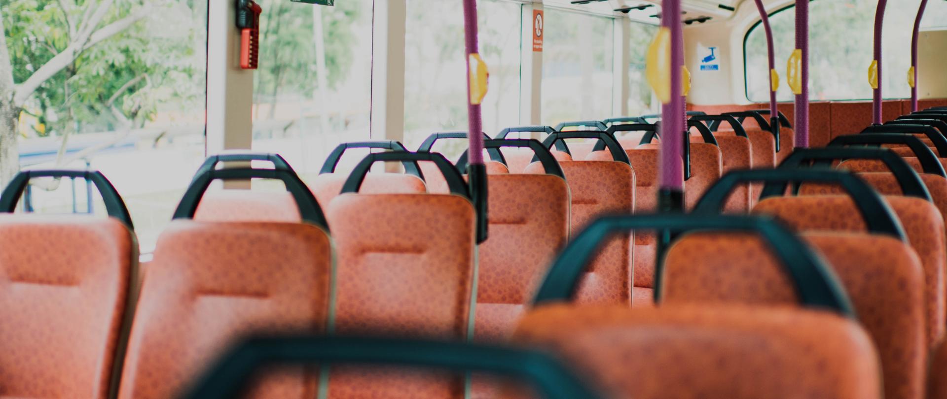 Wnętrze autobusu z pomarańczowymi siedzeniami