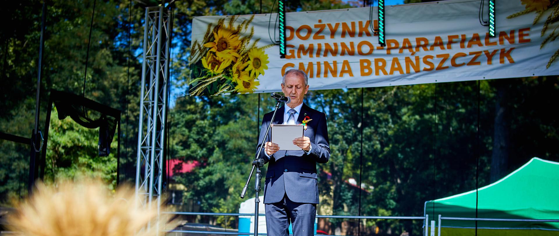 Na zdjęciu Wójt Wiesław Przybylski wygłaszający przemówienie na scenie.