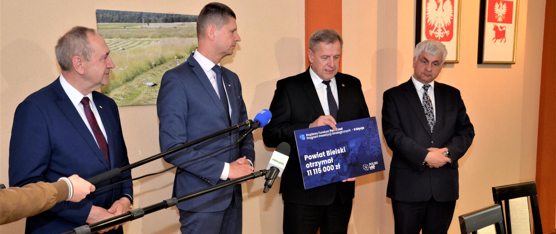 Starosta bielski Sławomir Jerzy Snarski prezentuje symboliczny czek z funduszami na realizację inwestycji w ramach Polskiego Ładu 
