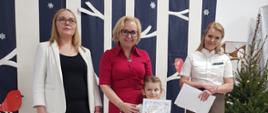 Dyrekcja Przedszkola wraz z przedstawicielką Nadleśnictwa Hajnówka wręczają nagrody dzieciom, pozując do wspólnego zdjęcia