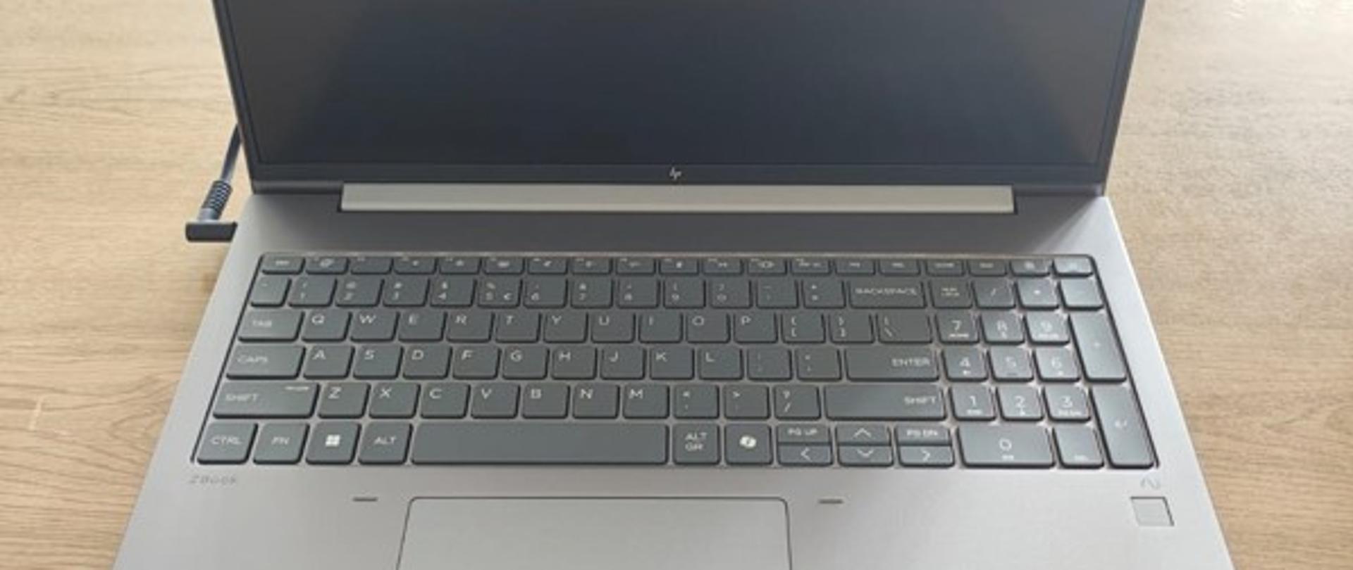 czarno srebrny laptop leży na stole 