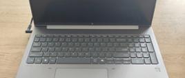 czarno srebrny laptop leży na stole 