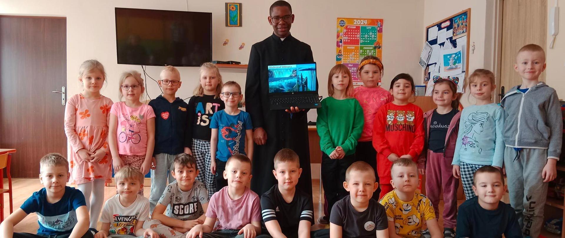 Grupa dzieci i 1 ciemnoskóry dorosły