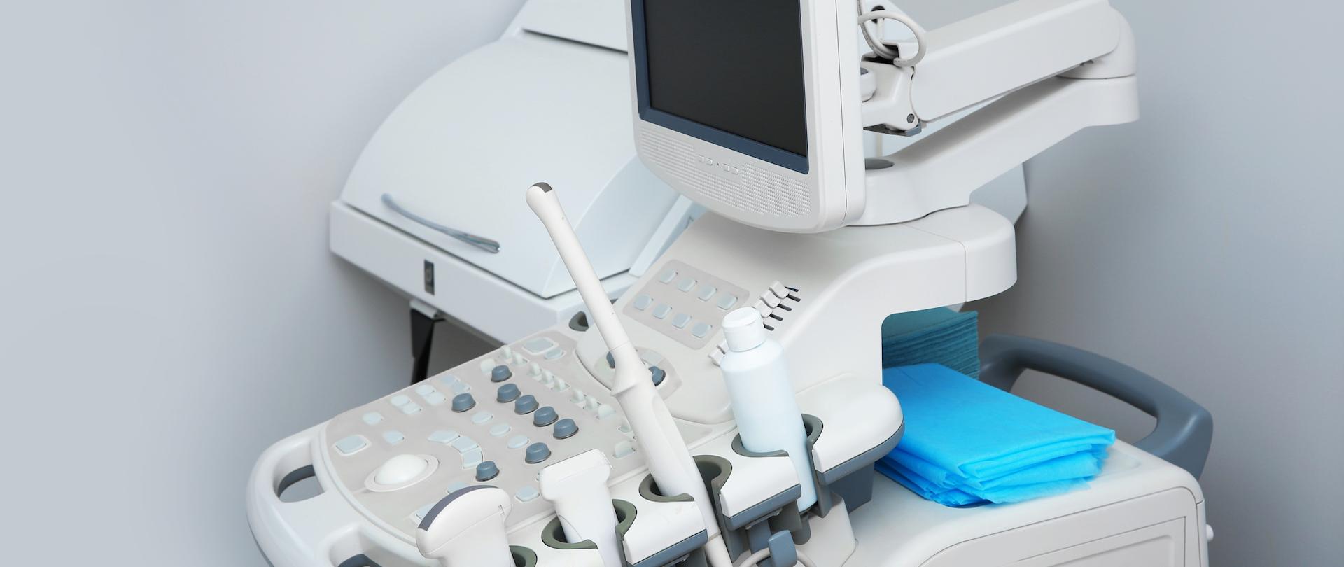 Modern ultrasound machine against white wall. Diagnostic equipment