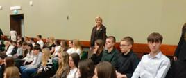 Zwiedzamy Sejm, młodzież siedzi w galerii na sali plenarnej