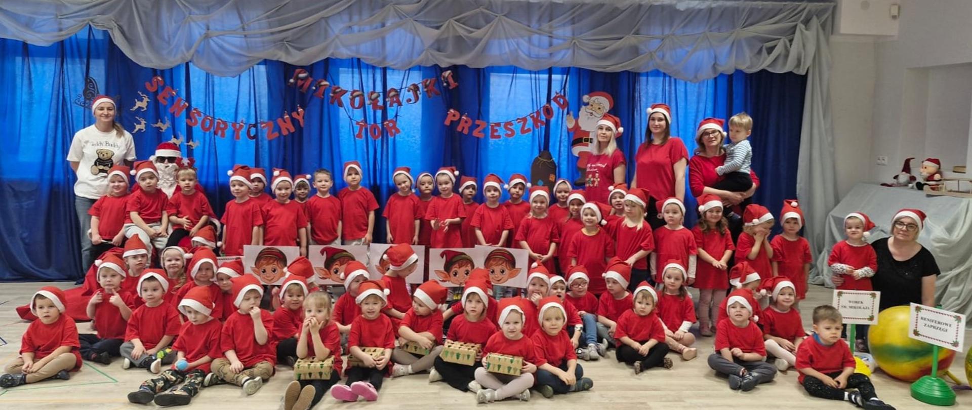 Mikołaj , 5 nauczycielek i dzieci w czerwonych koszulkach