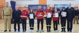 grupowe zdjęcie z nagrodzonymi uczestnikami III Wojewódzkich Halowych Młodzieżowych Zawodów Sportowo-Pożarniczych, w których udział wzięły drużyny z całego województwa podlaskiego.
