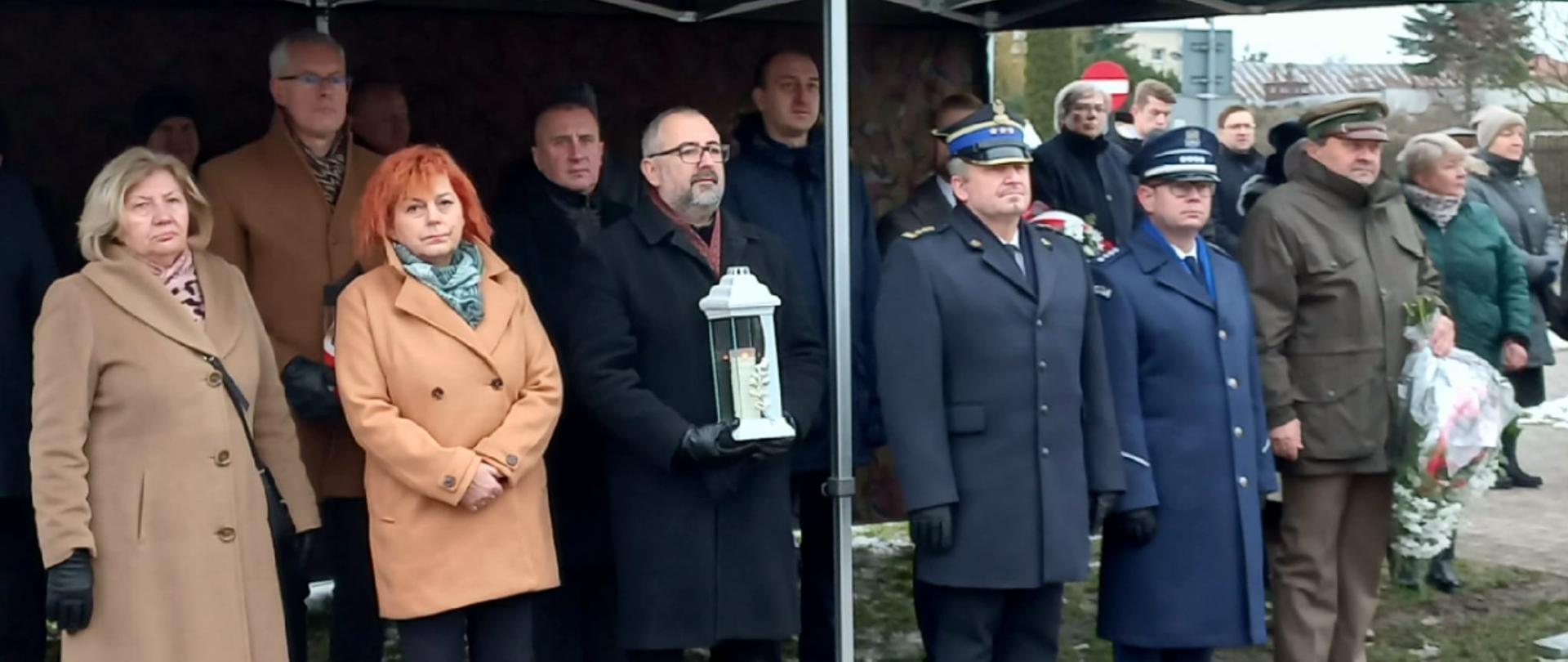 Zdjęcie przedstawia samorządowców oraz służby mundurowe z terenu powiatu przasnyskiego podczas obchodów rocznicy wybuchu Powstania Styczniowego.