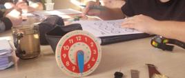 Uczymy się odczytywać godziny - przed uczniami lezą zegarki, oni w tym czasie rozwiązują zadania