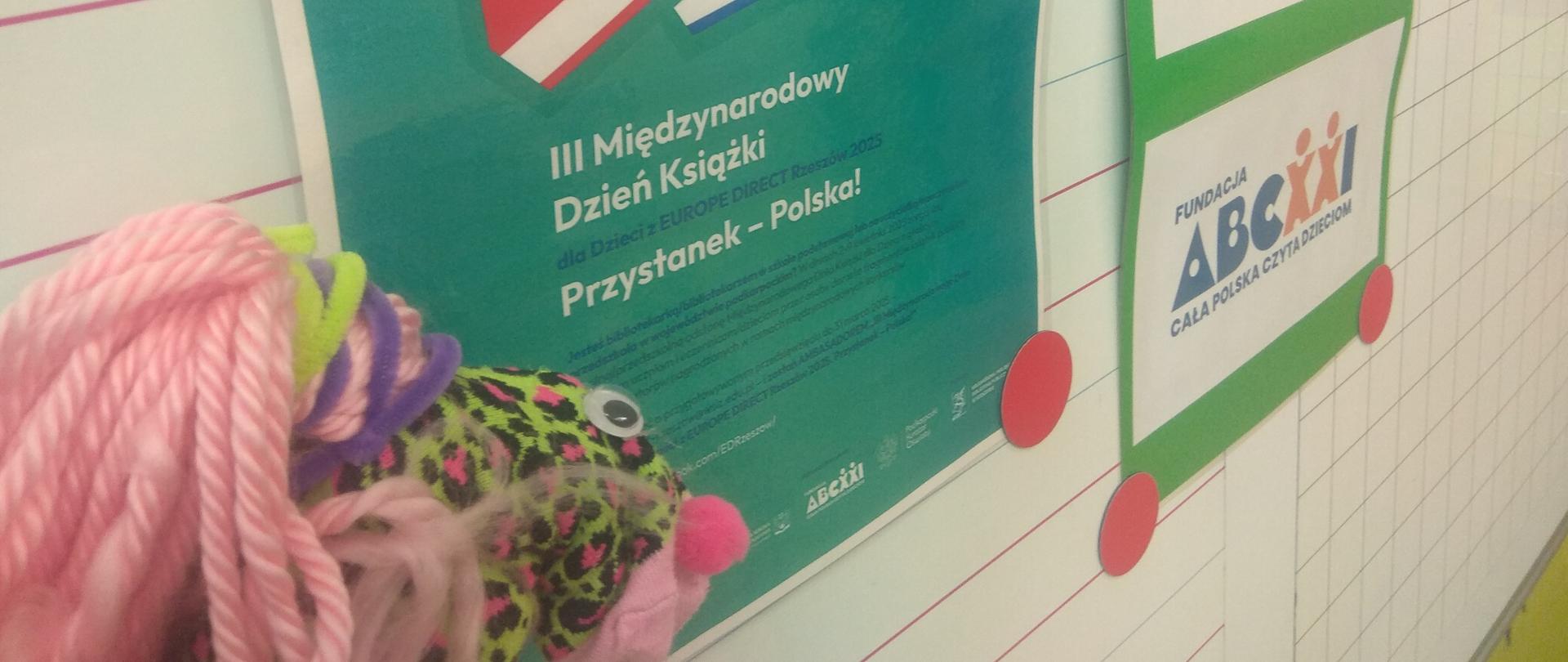 Po prawej plakaty promujące kampanię, po lewej wykonana przez ucznia pacynka ze skarpetki