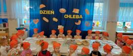 Dzieci w pomarańczowych chustach przy stole 