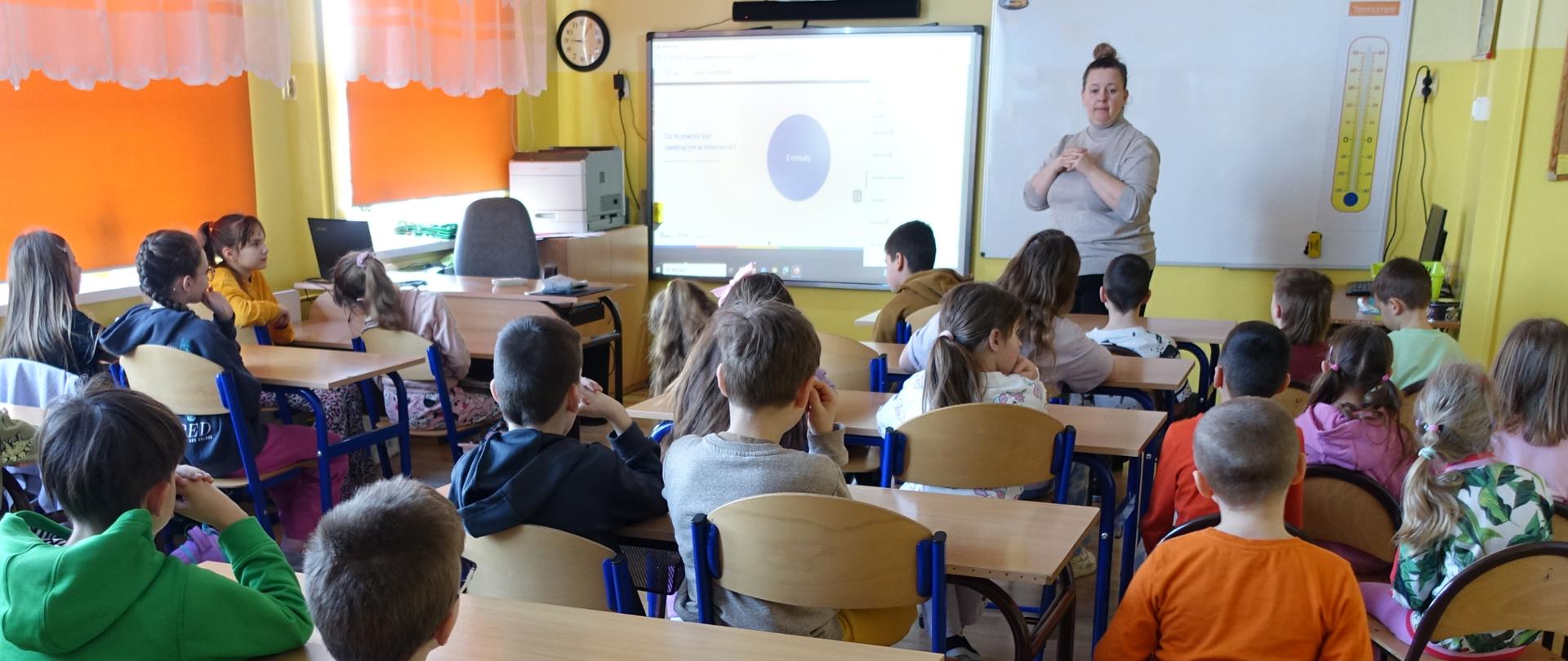 Uczniowie klas I-III w sali lekcyjnej biorą udział w lekcji online