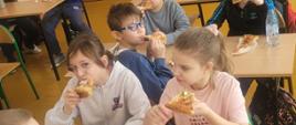 Grupa dzieci jedząca pizzę