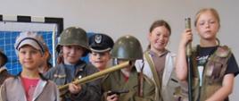uczniowie przebrani w stroje z okresu pierwszej i drugiej wojny światowej pozują do zdjęcia 