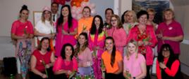 Grupa kobiet ubranych w kolorowe sportowe stroje z tulipanami w ręku oraz mężczyzna elegancko ubrany z przodu kosz z tulipanami