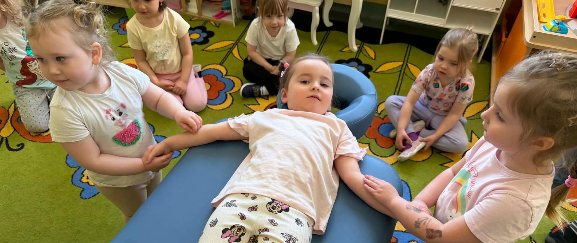 Dziewczynka leżąca na łóżku rehabilitacyjnym