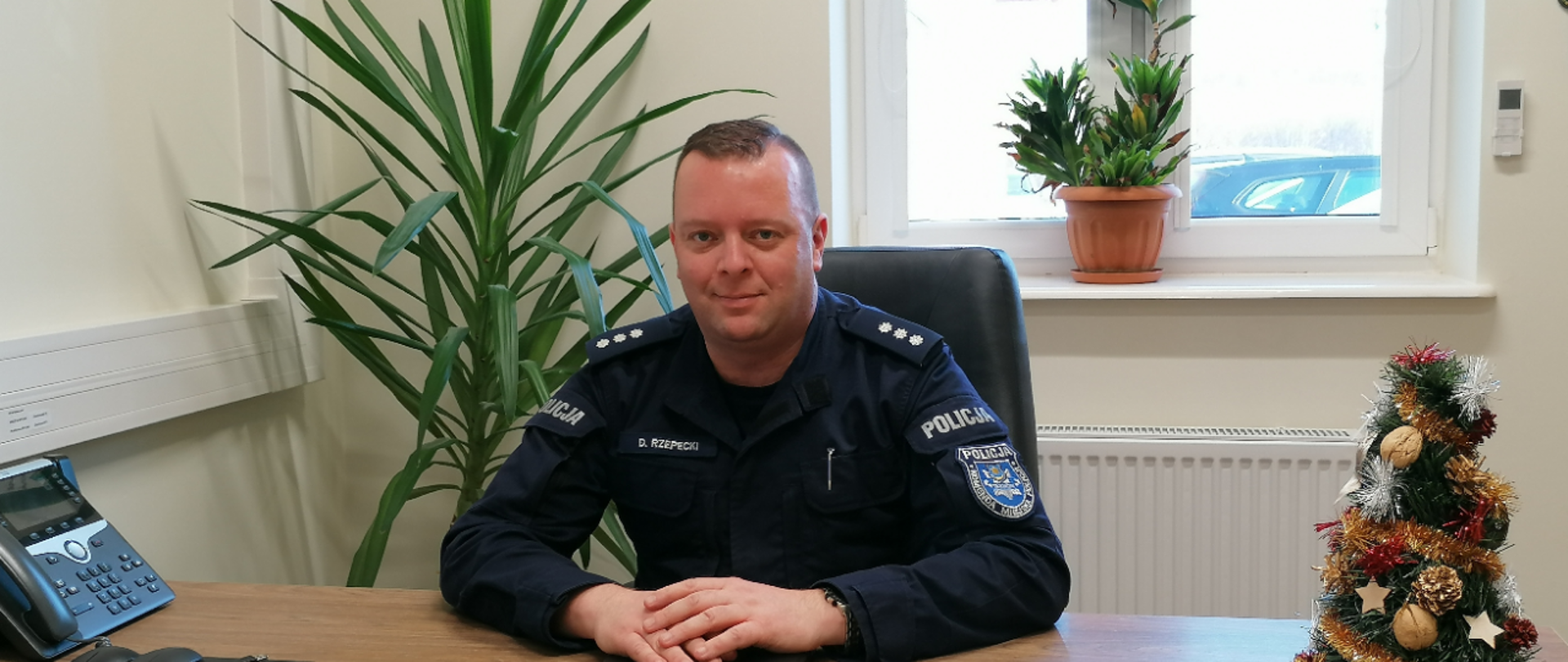 Komendanta Komisariatu Policji w Żabnie Pana Dominika Rzepeckiego za biurkiem.