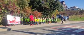 Dzieci wraz z bannerem przy przejściu dla pieszych