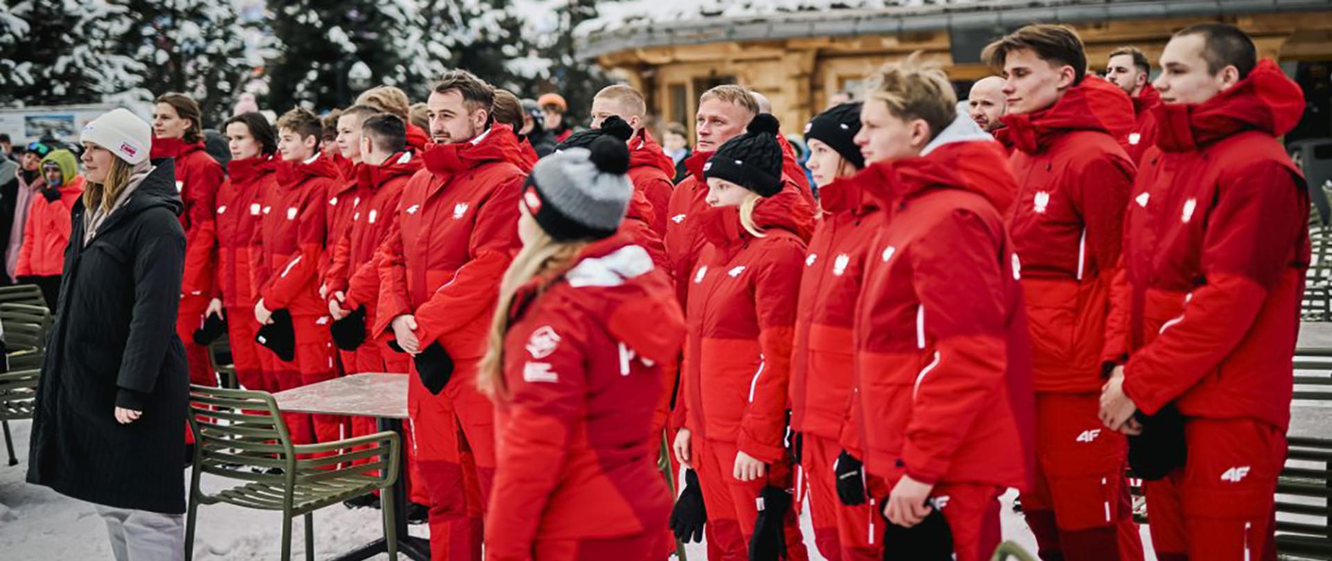 Grupa młodzieży w czerwonych strojach zimowych w zimowej aurze