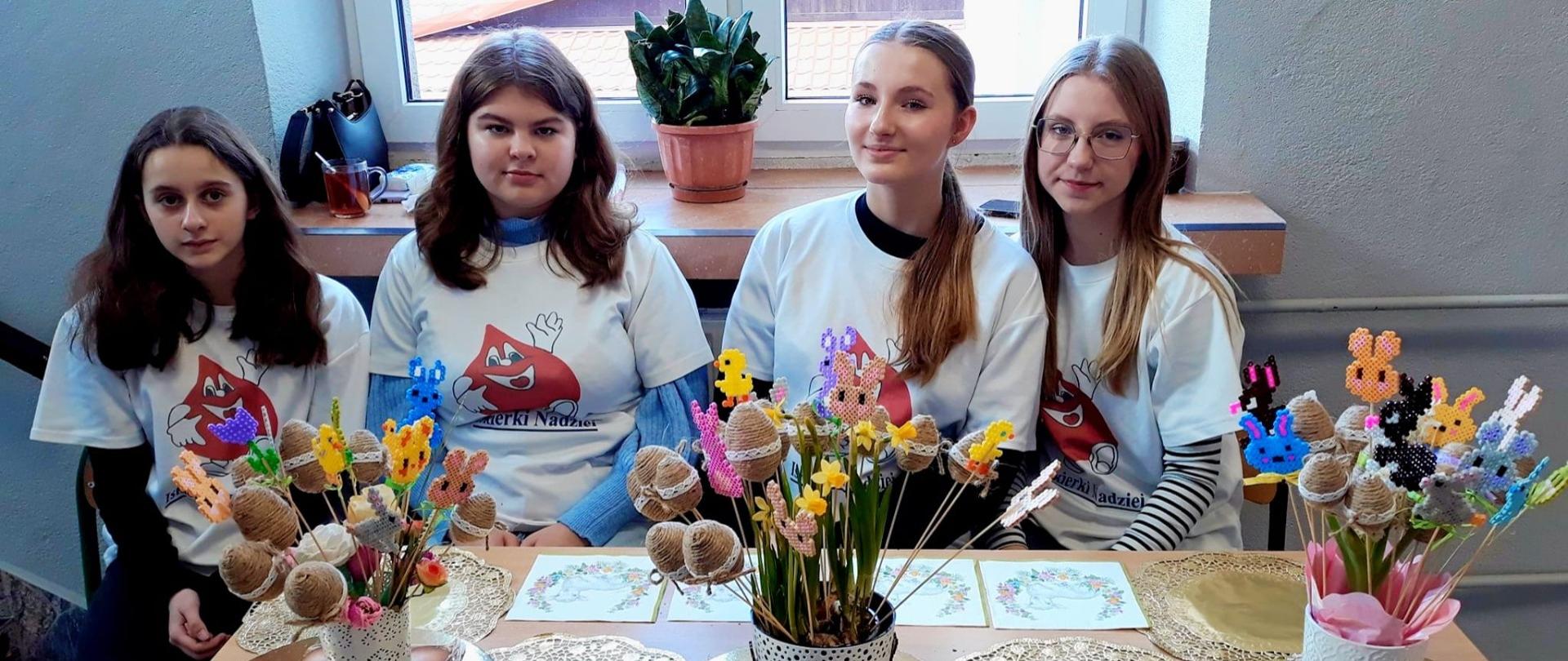 Dziewczęta ze Szkolnego Koła Wolontariatu w koszulkach z napisem "ISKIERKA NADZIEI" oraz przygotowanymi wielkanocnymi upominkami dla honorowych dawców krwi. 
