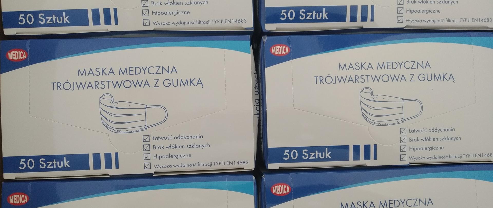 Sześć prostokątnych pudełek z grafiką maseczki jednorazowej i napisem Maseczka medyczna trójwarstwowa z gumką