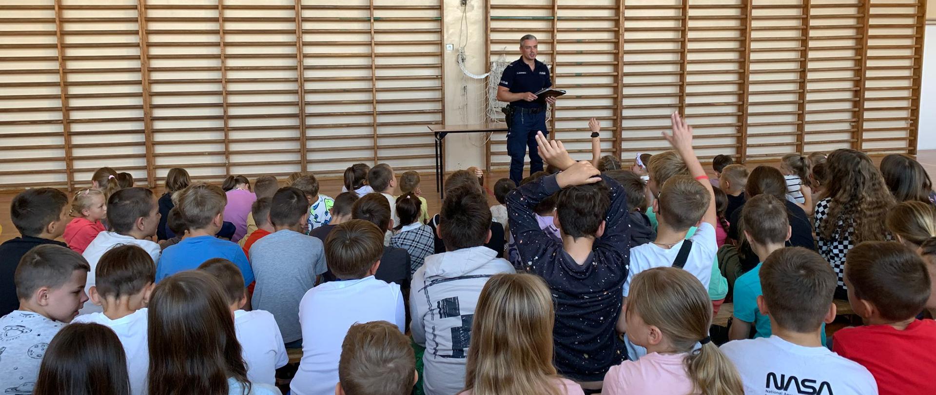 Policjant odpowiada na pytania uczniów.